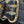 Close-up of a dark indigo denim belt with yellow contrast stitching and a silver-toned metal buckle.