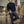 Man in a black sweater and pants standing on a set of stairs.
