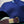 Blue cap with a brown leather strap on a tiled surface