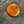 A round copper-colored metal button with crossed tools and the year 1998, shown on a textured gray denim fabric background.